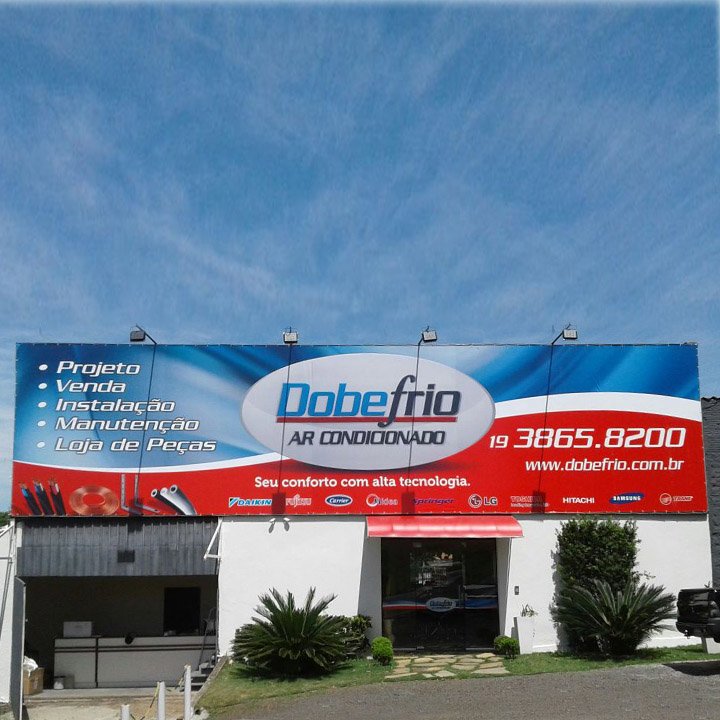Painel de fachada em lona de grande formato instalado sobre loja